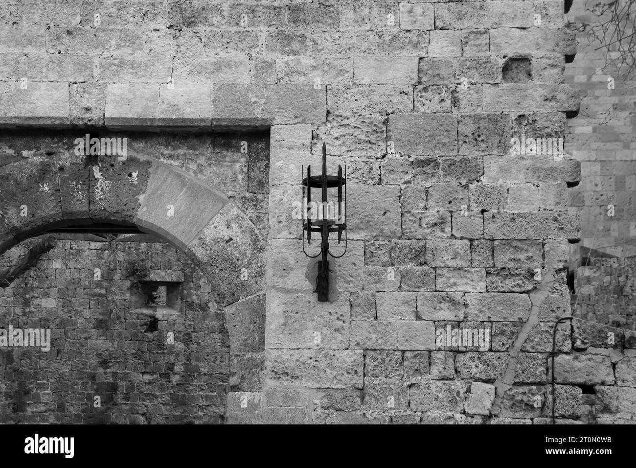 Ancient vintage medieval design style wall lamp on the sides of the entrance to the Gate of Amboise Rhodes Old Town in black and white Stock Photo