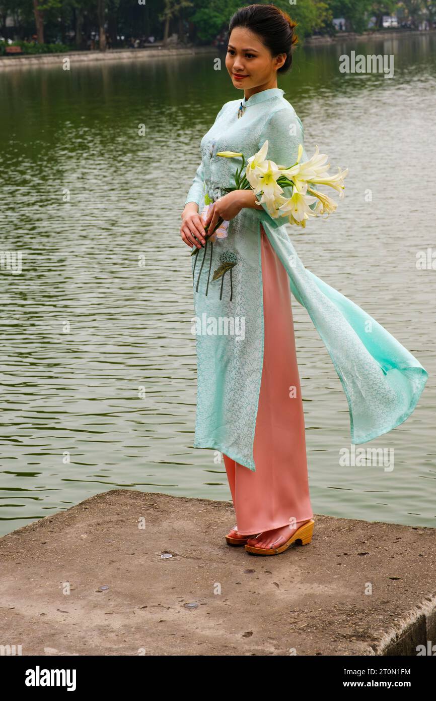 Hanoi, Vietnam. Young Woman Wearing an Ao Dai at Lake Hoan Kiem. Stock Photo