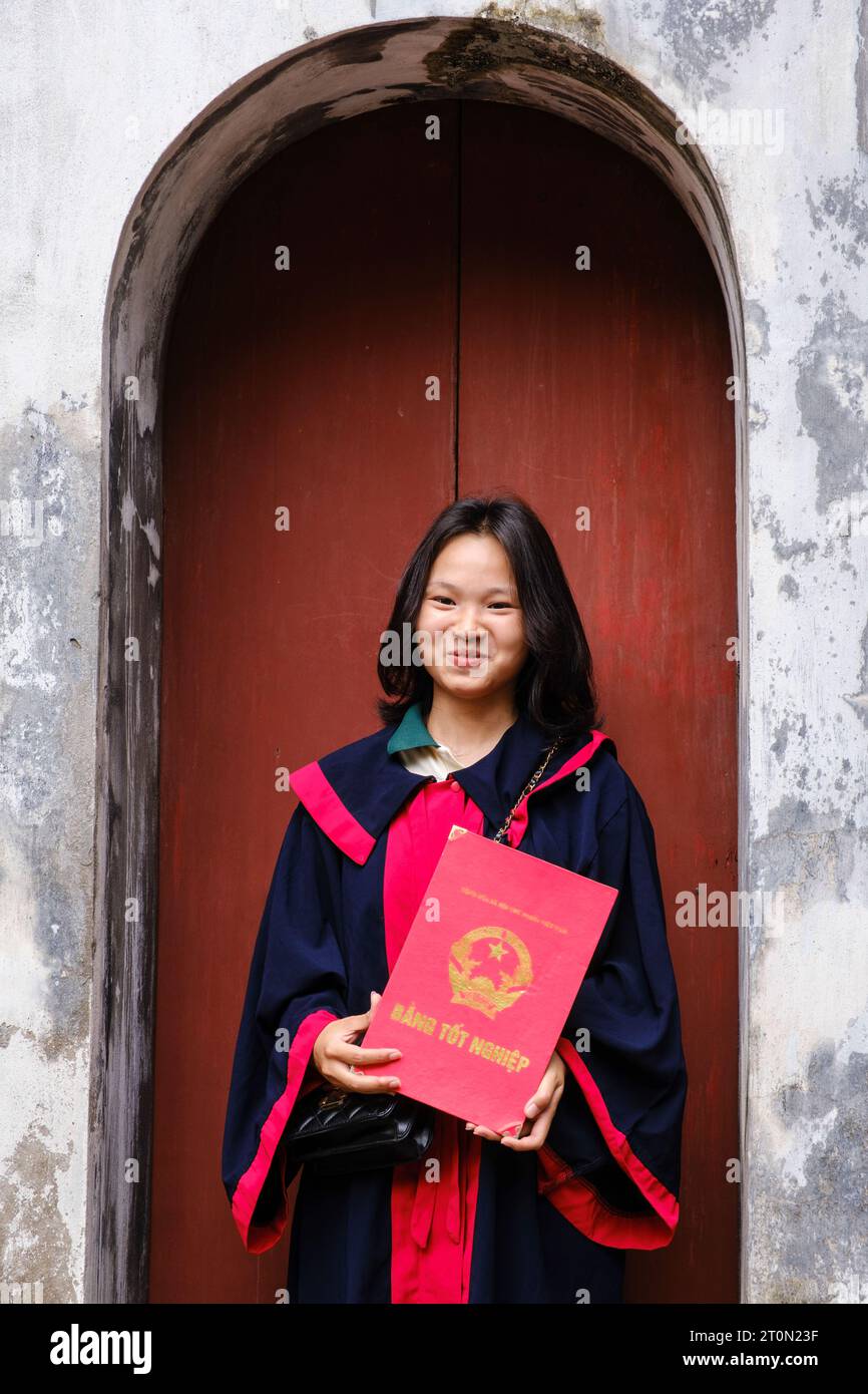 Hanoi, Vietnam. Temple of Literature, Van Mieu. Young Woman Student Holding Graduation Certificate. Stock Photo