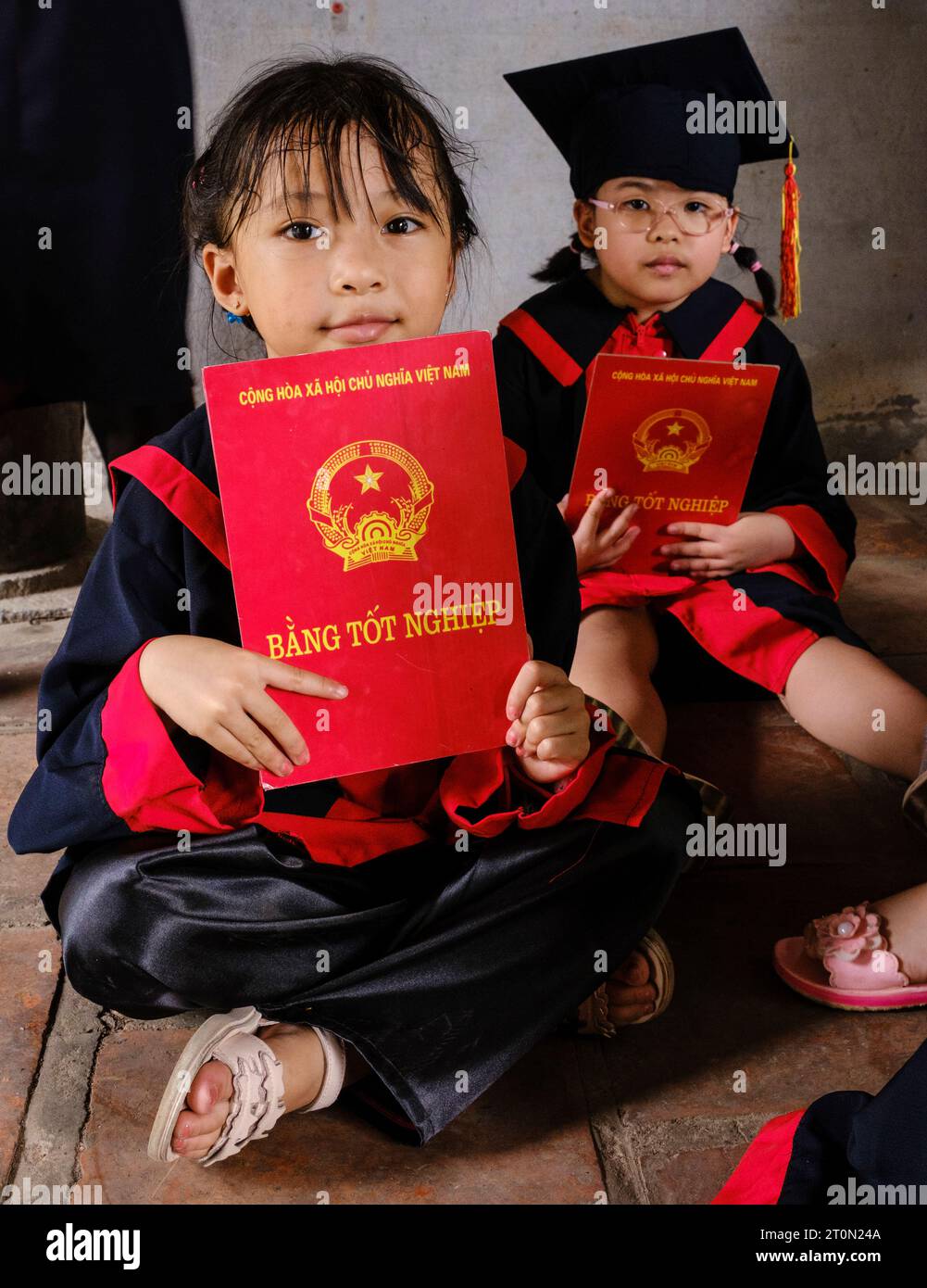 Hanoi, Vietnam. Temple of Literature, Van Mieu. Young Girl Students Holding Graduation Certificates. Stock Photo