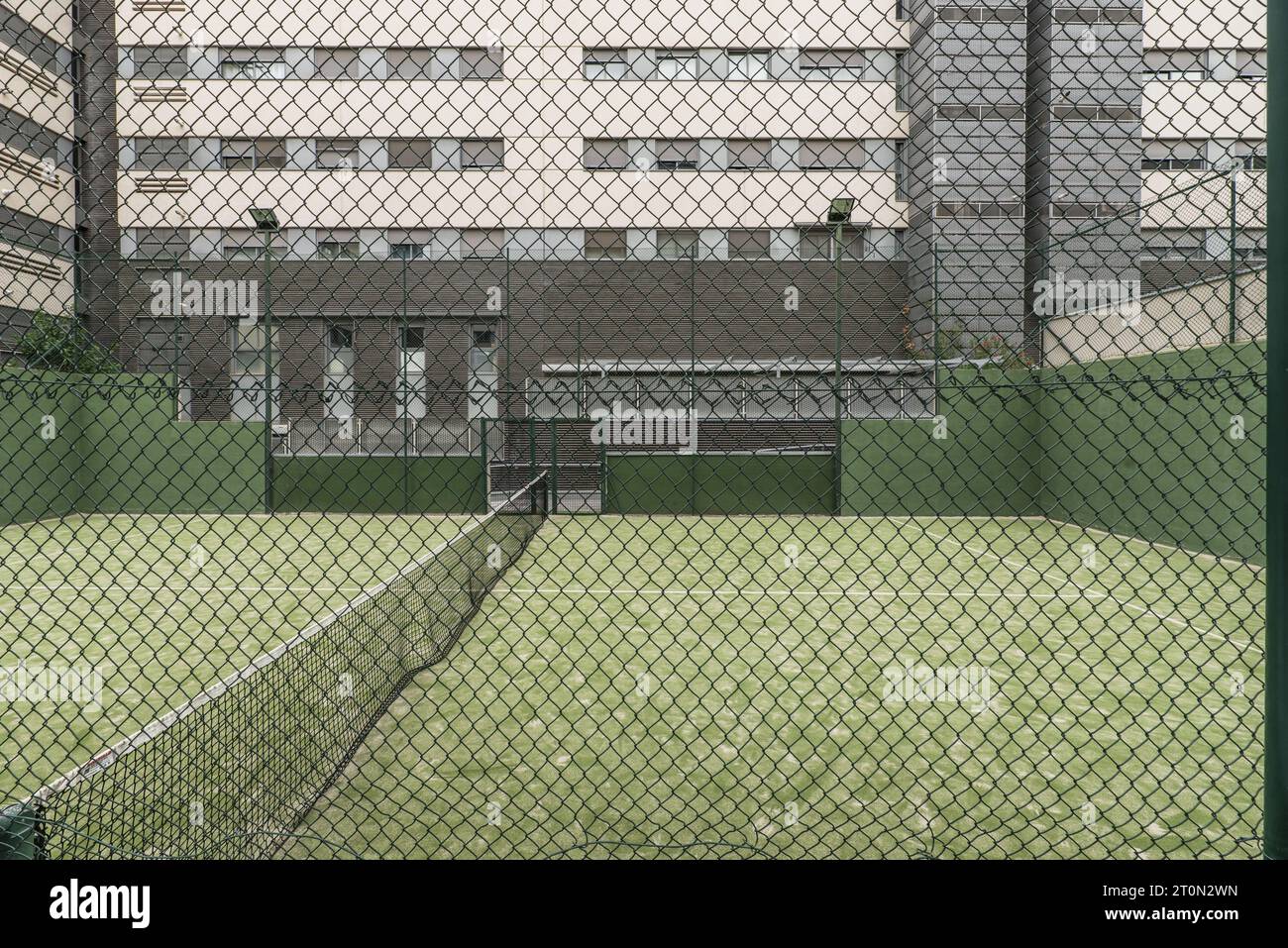 Paddle tennis court closed with metal fences, light bulbs Stock Photo