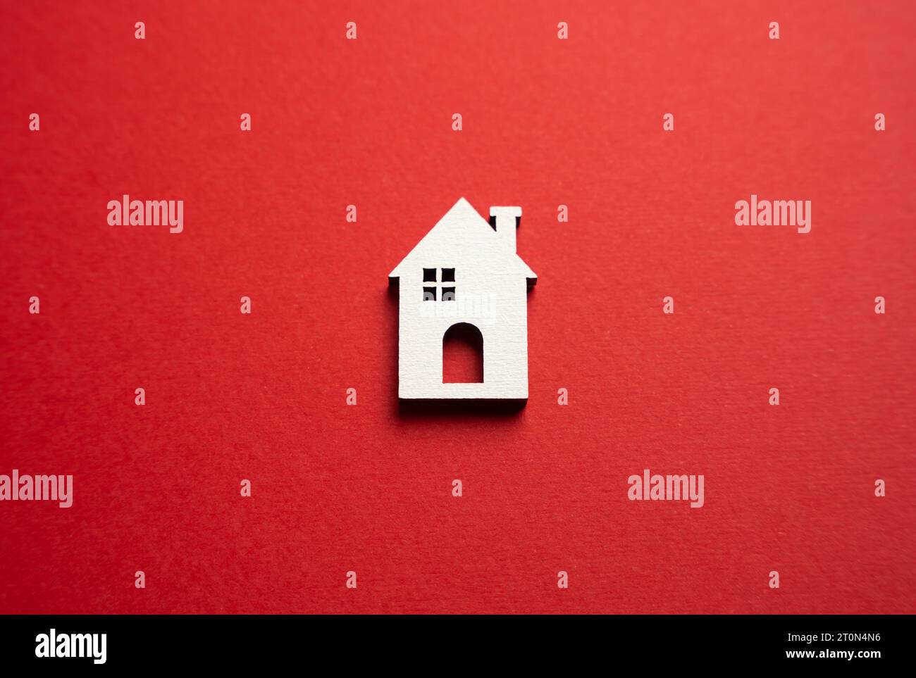House on a red background. Buying and selling housing. Real estate market review. Construction industry. Property insurance. Design and architectural Stock Photo