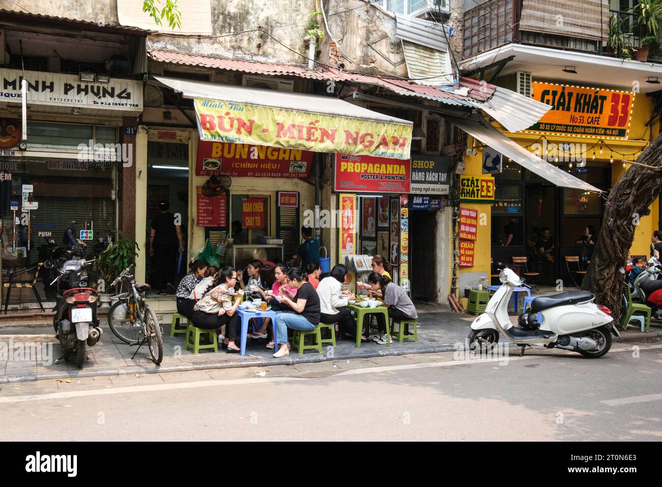 Hanoi, Vietnam. Street Scene, Old Quarter. Vietnamese Having Lunch at Sidewalk Cafe. Stock Photo