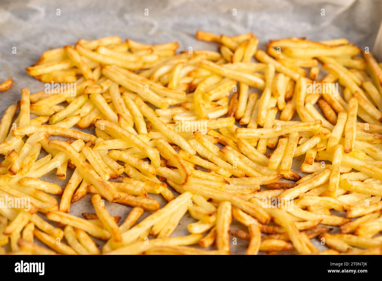 fried french fries lying on baking paper. Cooking frozen French fries