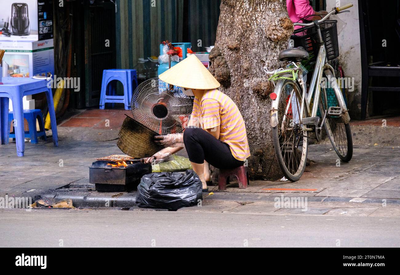 Hanoi, Vietnam. Woman Preparing Charcoal for Cooking Street Food. Stock Photo