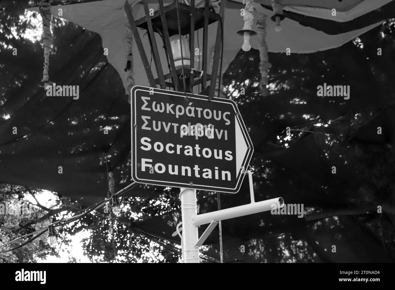 Black and white directional sign to Socratous fountain (Castellania fountain) located at the prime location of Ippokratous square in Rhodes, Old Town Stock Photo