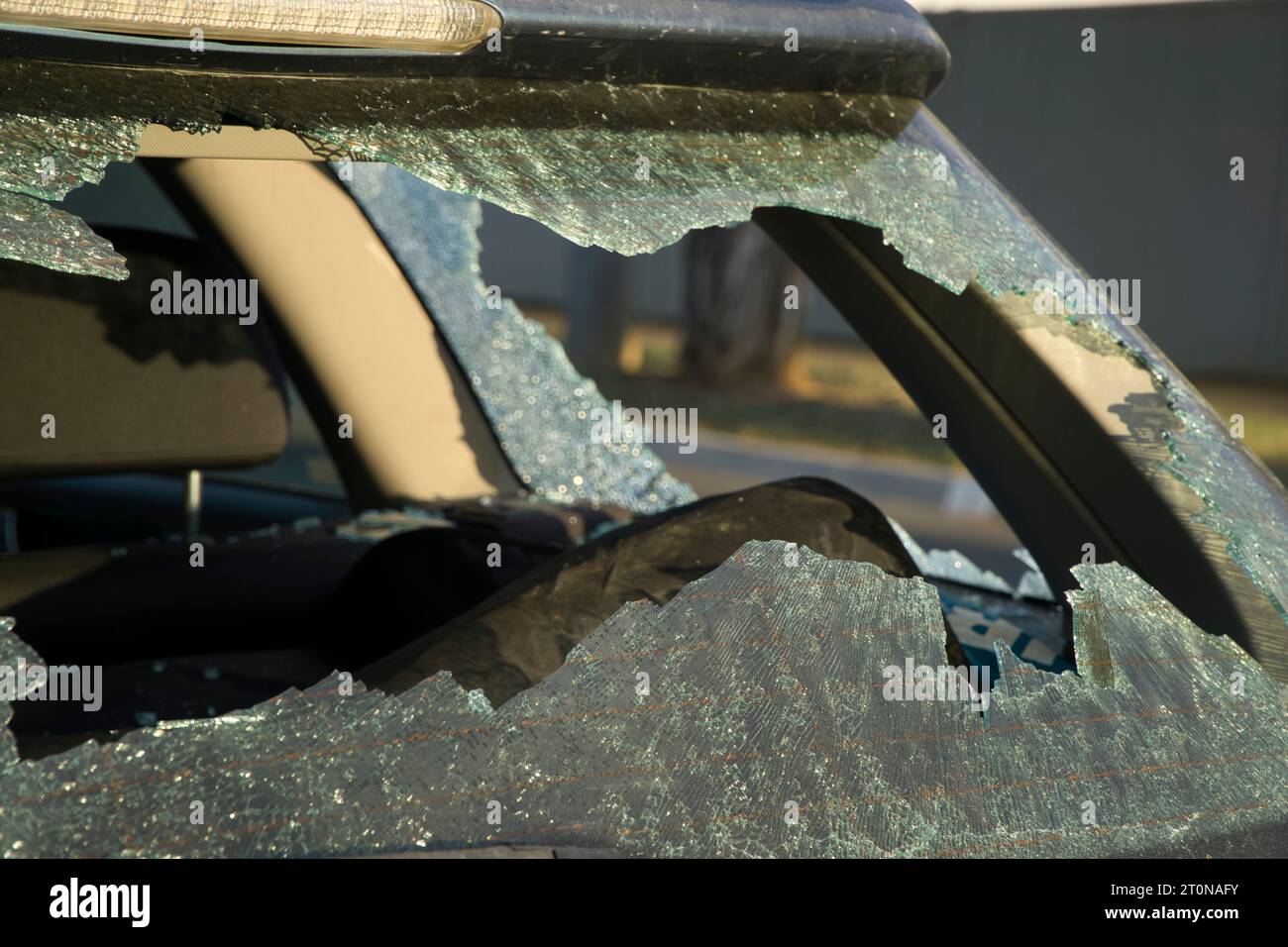 The vandalised shattered broken rear and side windows on a car in the street Stock Photo