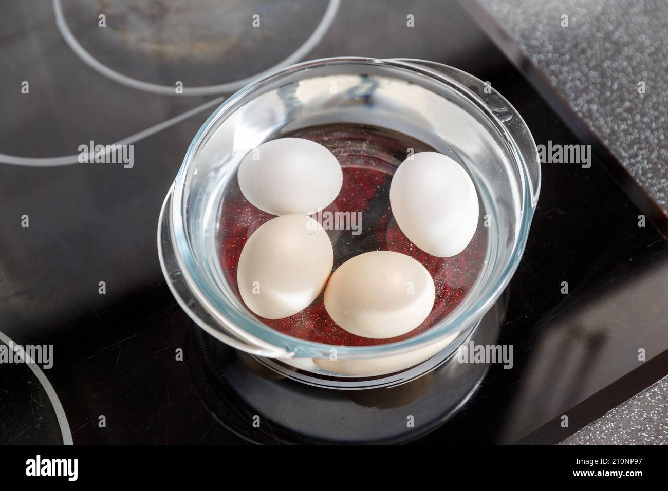 Eggs in a water in glass pot on  electric stove.  Boiled eggs cooking Stock Photo