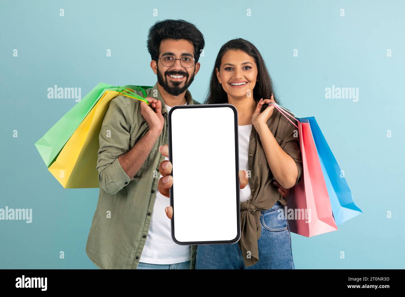 Cheerful indian couple using nice shopping mobile app, copy space Stock Photo