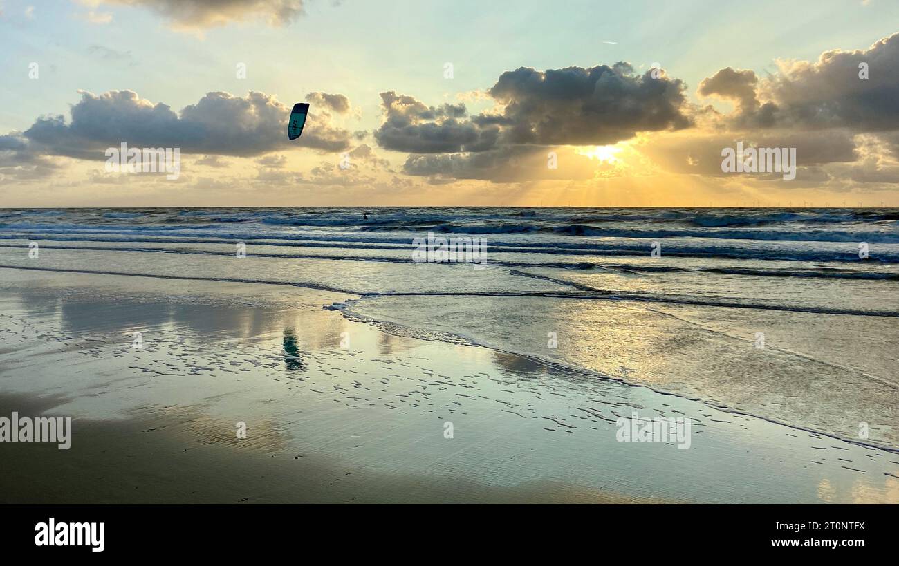 Kitesurfer on the rough Dutch North Sea at sunset. Egmond aan Zee, the Netherlands, Europe. Stock Photo