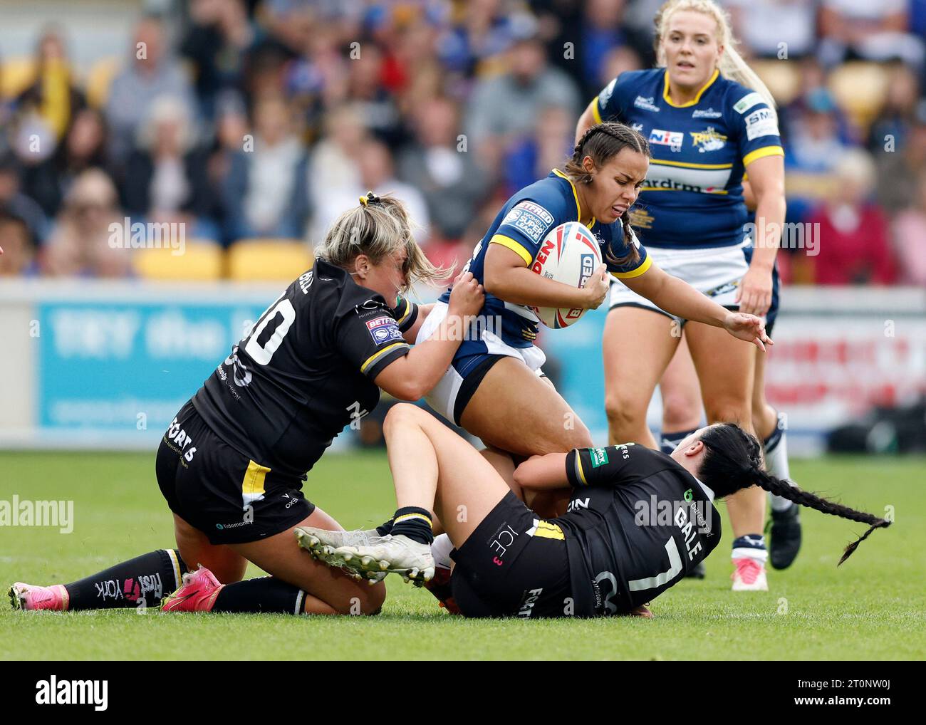 Leeds Rhinos' Jasmine Cudjoe is tackled by York Valkyrie's Jas Bell and Liv Gale during the Betfred Women's Super League Grand Final match at the LNER Community Stadium, York. Picture date: Sunday October 8, 2023. Stock Photo