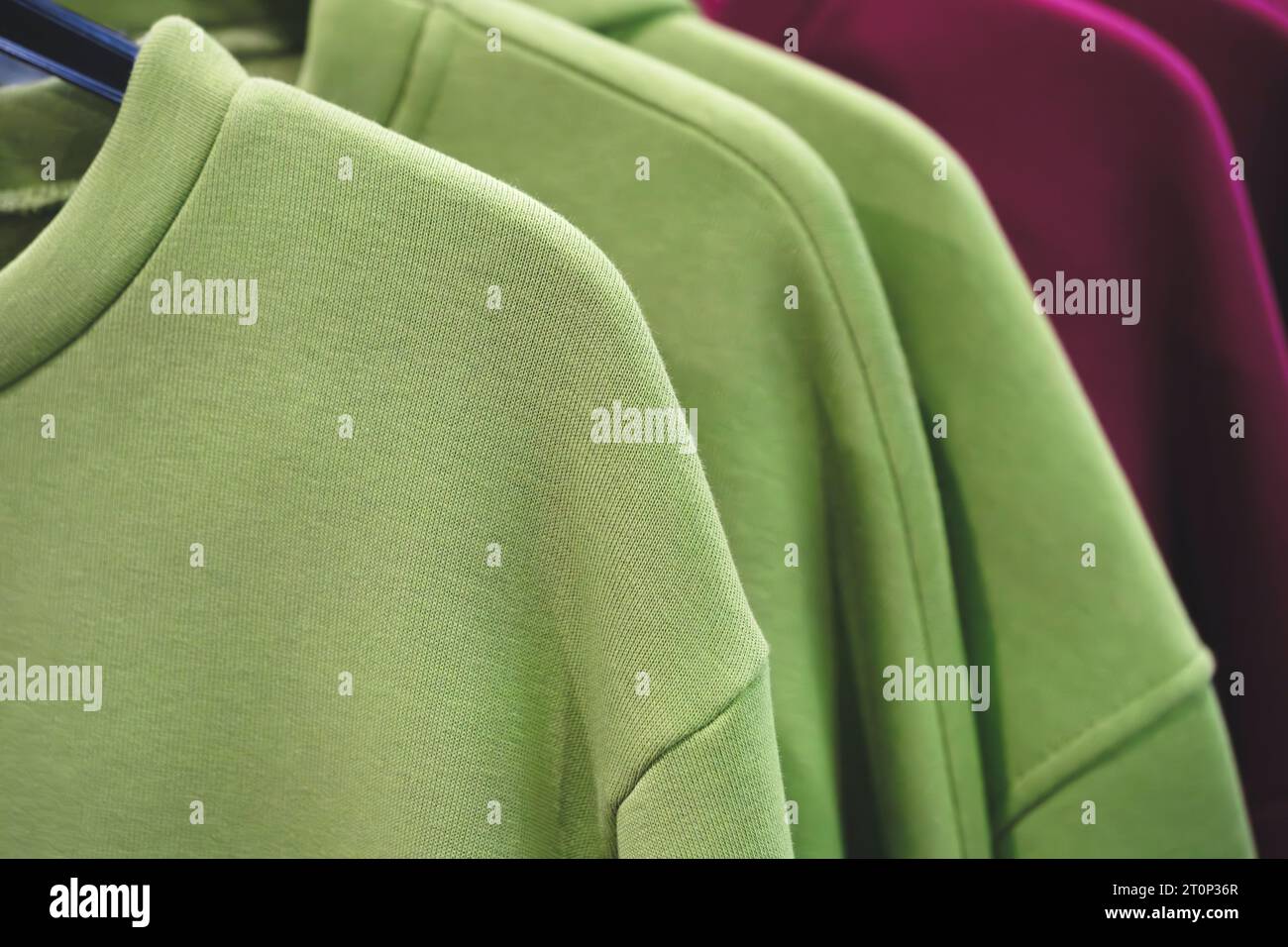 Fashion hoodie clothes on clothing rack Closeup of rainbow color choice ...