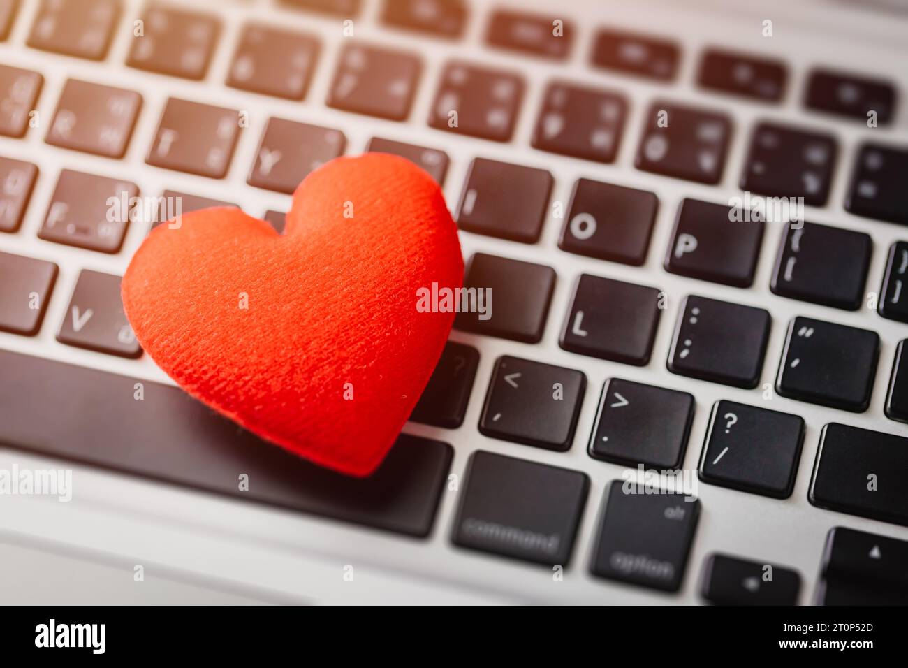 Red heart on laptop keyboard flirt love chat or lover online text messenger for meeting date Stock Photo