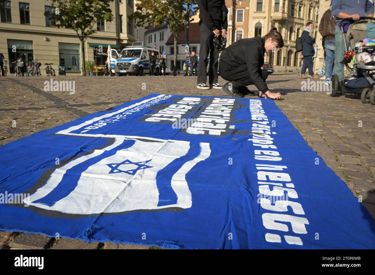 08 October 2023, Saxony-Anhalt, Halle (Saale): A banner is spread on the ground by demo participants. Over 150 participants have come to Halle's Hallmarkt for the rally 'Solidarity with Israel! No peace with anti-Semites'. The background is the attack by Hamas on Israel. Photo: Heiko Rebsch/dpa Stock Photo