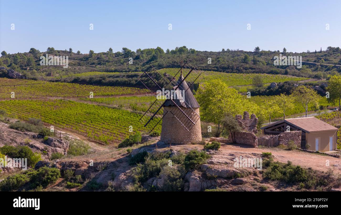 This photo shows an old wind mill between the grape fields in the town of Saint-Chinian, France. Stock Photo