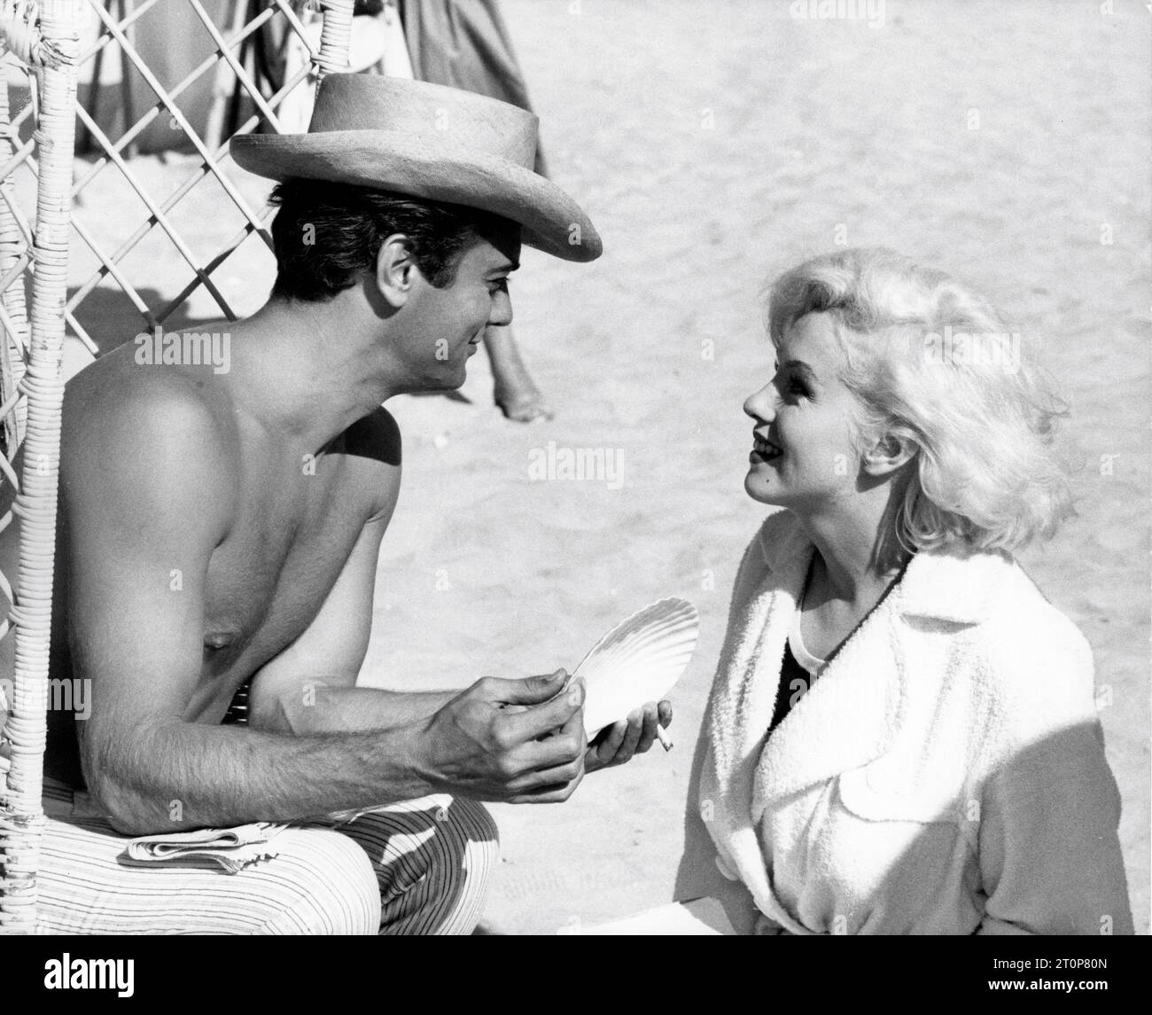 TONY CURTIS and MARILYN MONROE on set location rehearsal candid on Coronado Beach, California during filming of SOME LIKE IT HOT 1959 director BILLY WILDER screenplay Billy Wilder and I.A.L. Diamond Ashton Productions / The Mirisch Corporation / United Artists Stock Photo