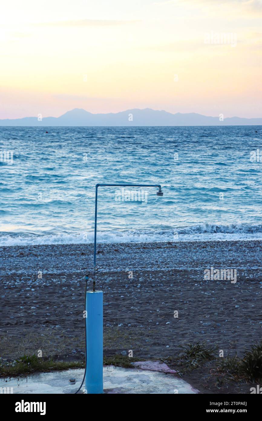 Outdoor beach shower in front of the ocean at Paralia Ixia beach during sunset Stock Photo Alamy