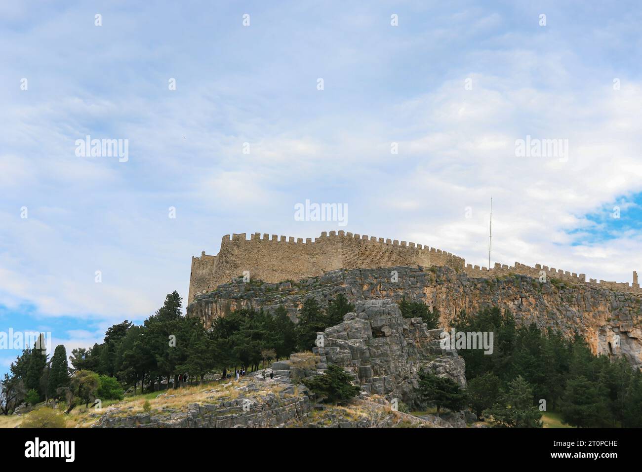 View from Lindos of the Acropolis of Lindos fortress on top of a mountain Stock Photo