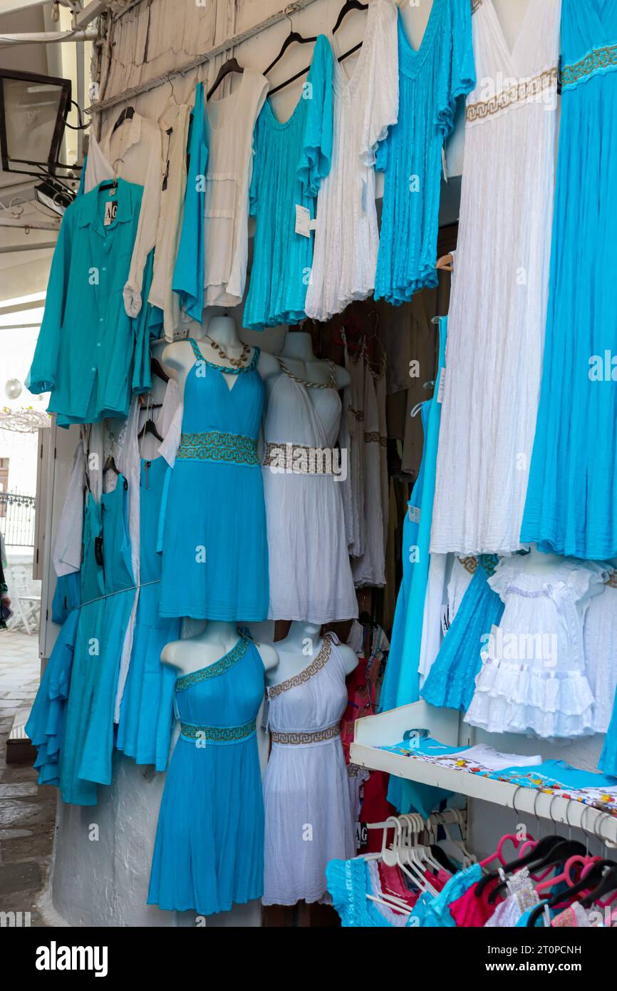 Lindos street market selling blue and white dresses displayed hanging outside on the way up to The Acropolis of Lindos Stock Photo