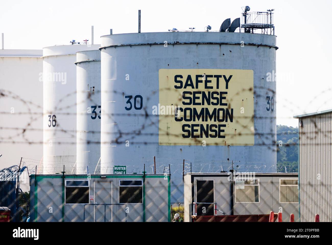 Petrol tankers with the message 'Safety Sense Common Sense' at an oil storage depot. Stock Photo