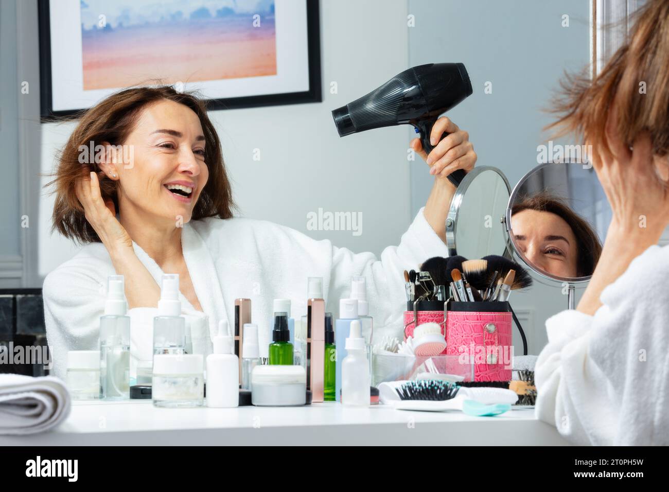 Mature woman blow drying hair hi-res stock photography and images - Alamy
