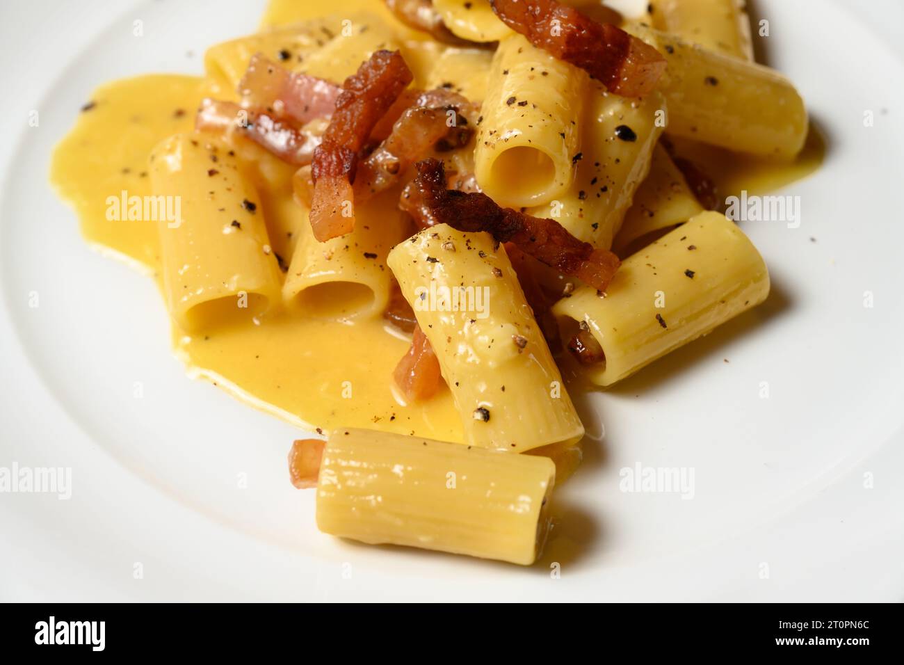 Rigatoni Carbonara Pasta with Eggs, Pecorino Romano and Guanciale in the Roman or Lazio Style Stock Photo