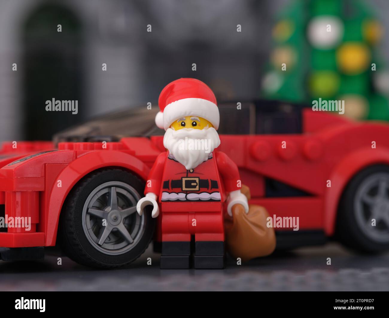Tambov, Russian Federation - October 08, 2023 A Lego Santa Claus minifigure standing in front of a Ferrari LaFerrari car and holding a sack of present Stock Photo