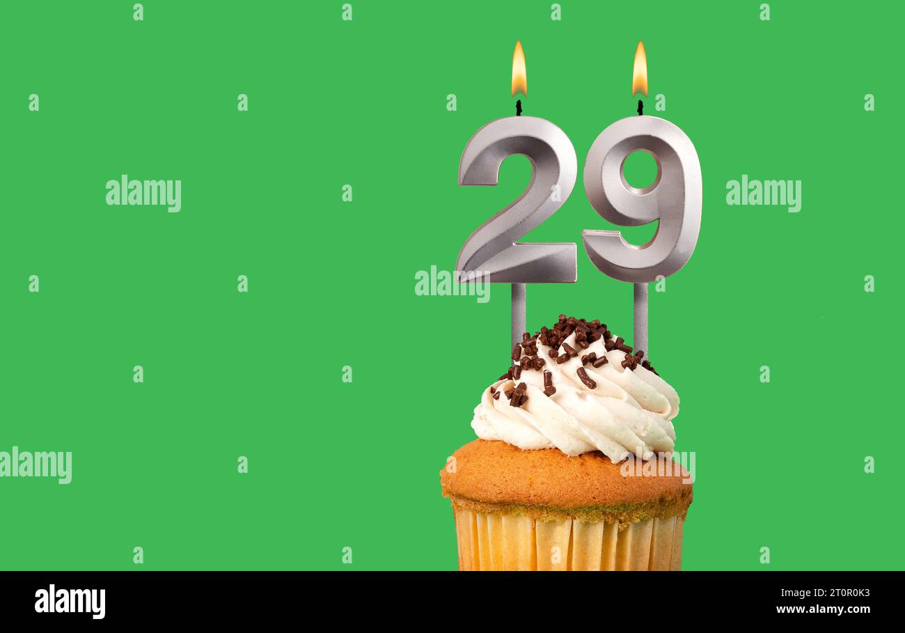 Birthday card with candle number 29 - Cupcake on green background Stock Photo