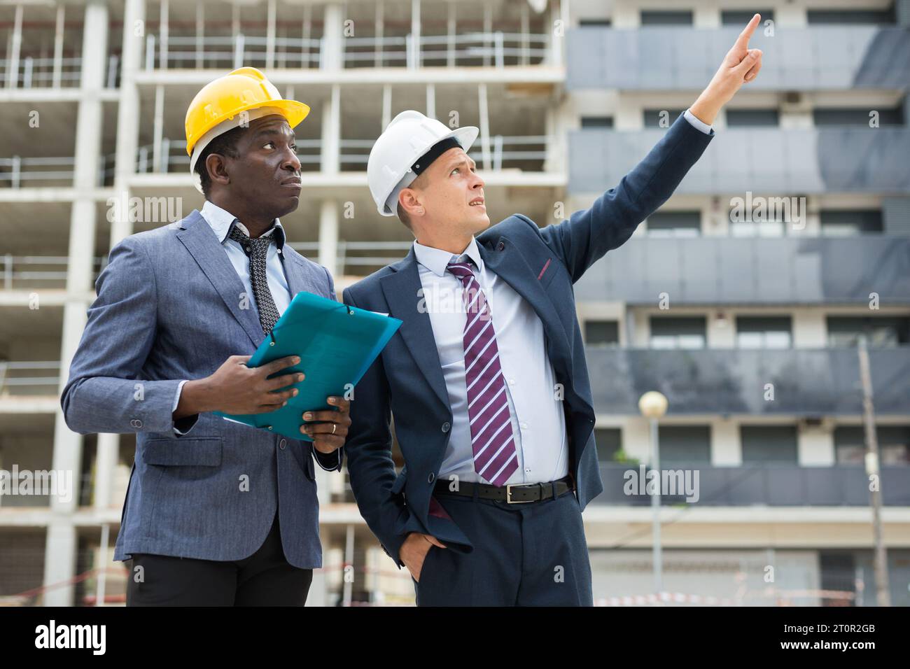 Two architects inspect the construction of new building. One of them ...