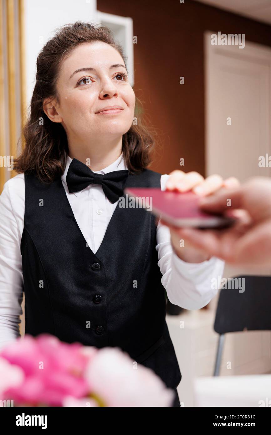 Female concierge eagerly and assists elderly traveler, checks