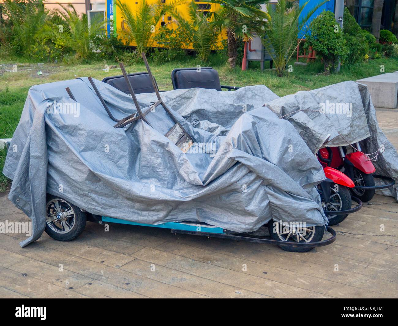 Vehicles at the resort are covered with tarps. Bicycles and scooters at
