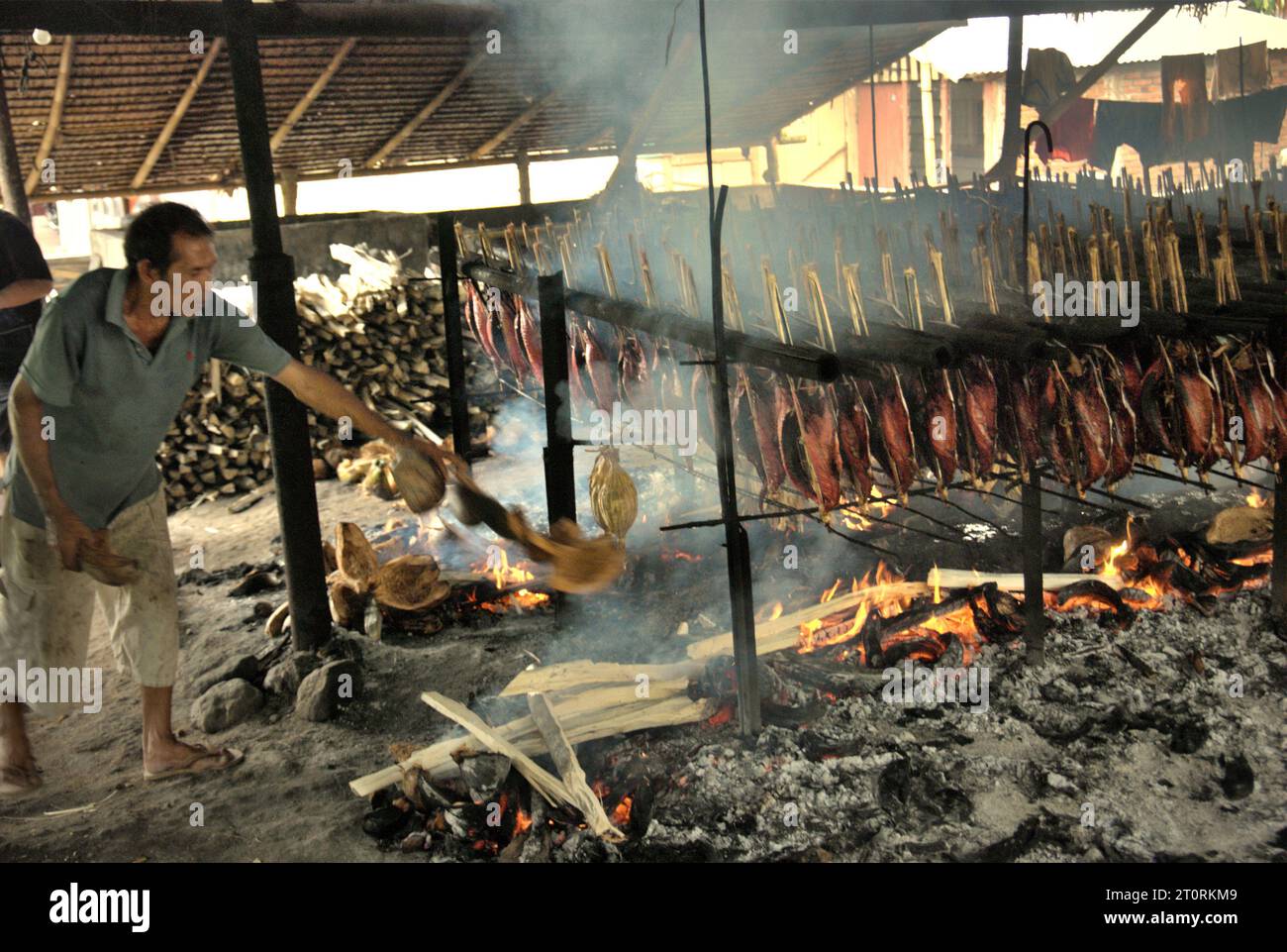 A worker maintains the equal distribution of coconut husks that are
