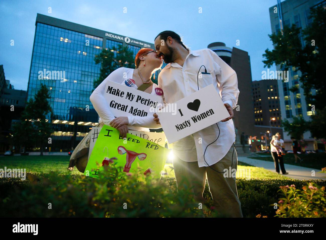 November 2, 2016 - Indianapolis, Indiana, USA: Elisabeth Faulkner, left, holds a sign reading, Make My Period Great Again, and Mike Faulkner has a sign reading, I (heart) Nasty Women, during a Periods for Politicians formerly Periods for Pence stage an anti-Trump and anti-Pence The Revolution Will Be Uterized (A Rally in 3 Acts) on the steps of the Indiana Statehouse.  (Jeremy Hogan/Polaris) Stock Photo