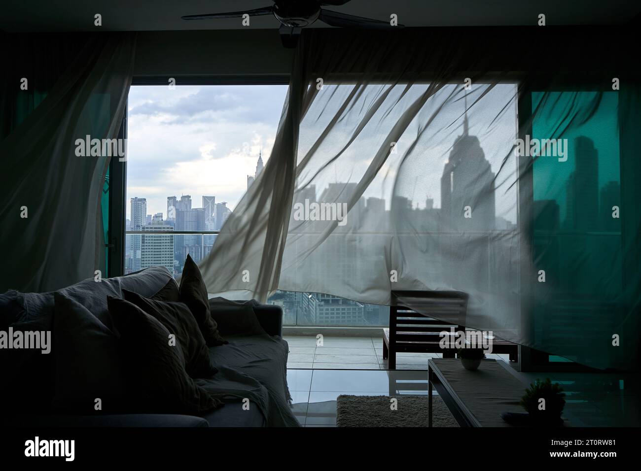 The Wind Rustles The wind rustles the curtain of the panoramic window with a cityscape ...