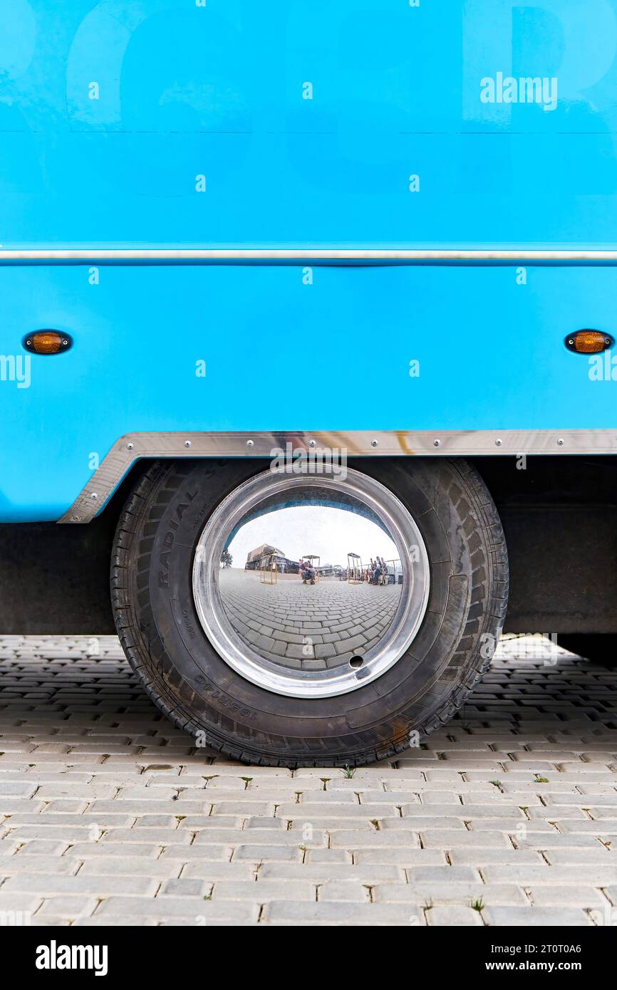 Wheel with shiny disks of large blue food truck on city street. Vehicle with portable cafe for town visitors. Large car providing fast food Stock Photo