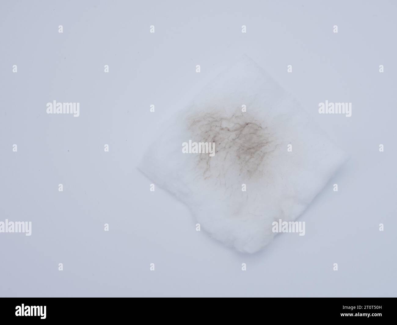 Used dirty cotton pad to clean face on white background, removing