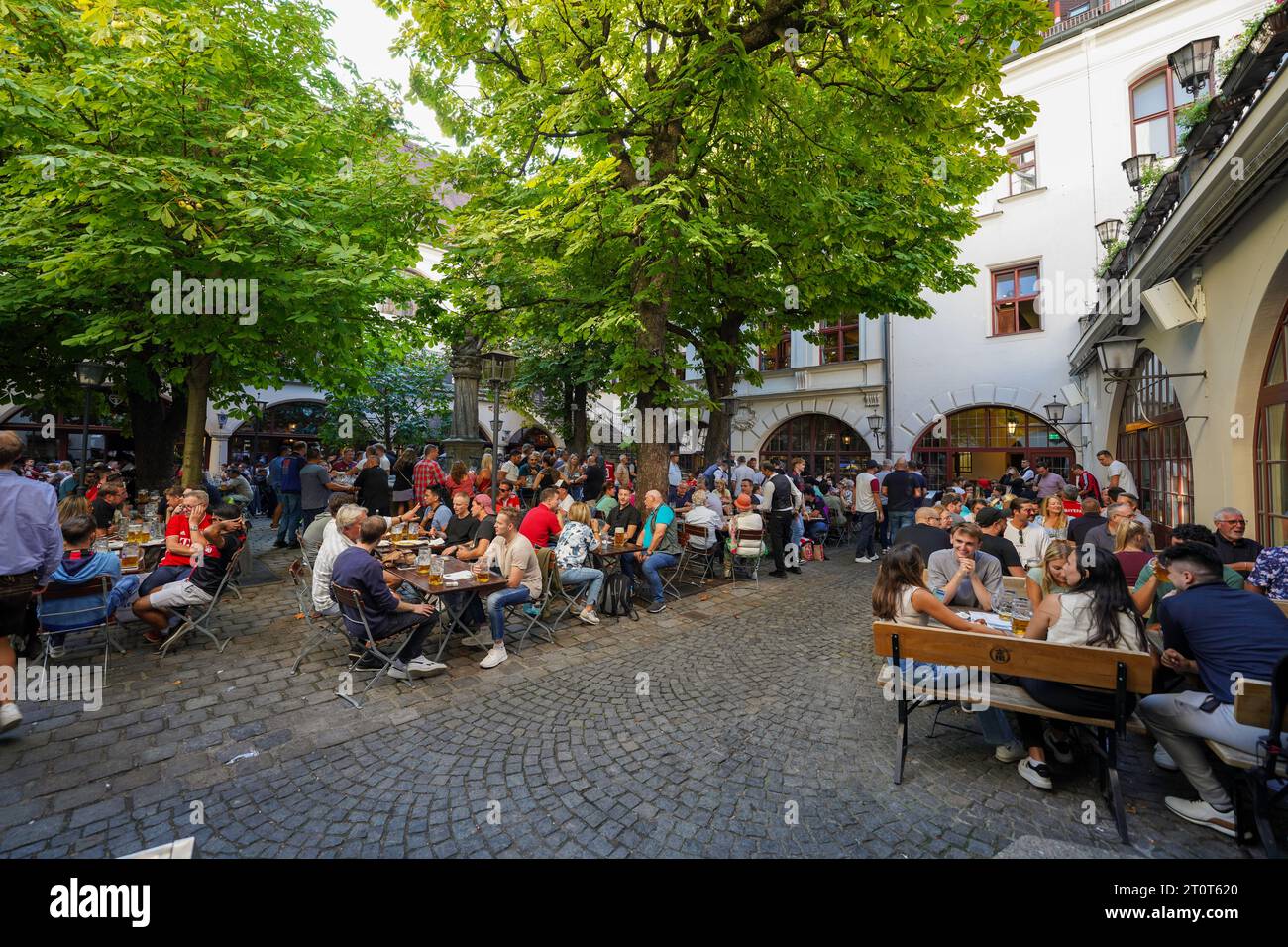 Munich, Germany, EU - Sept. 15, 2023. Hofbräuhaus München beer hall, outdoor beer garden. Crowds, people drinking beer, eating at Hofbrauhaus Munich. Stock Photo