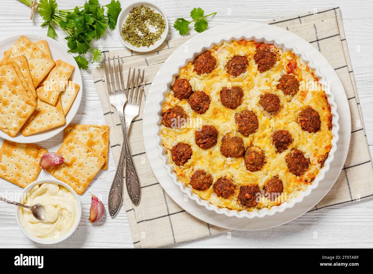 Meatball Hash Brown Casserole in baking dish on white wooden table with
