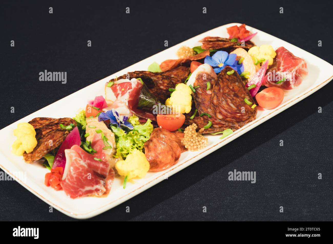 A closeup of a plate filled with a variety of cooked meats Stock Photo