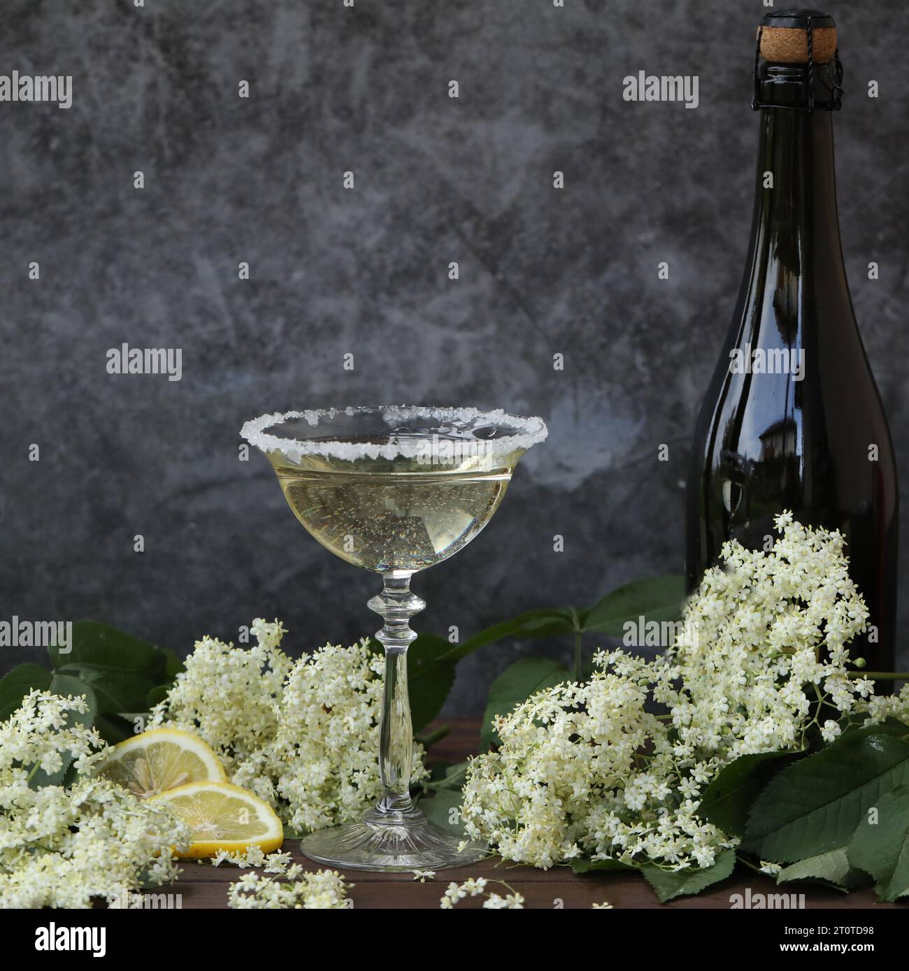 Glass and bottle of champagne with elderflower liqueur. On grey background with copy space Stock Photo