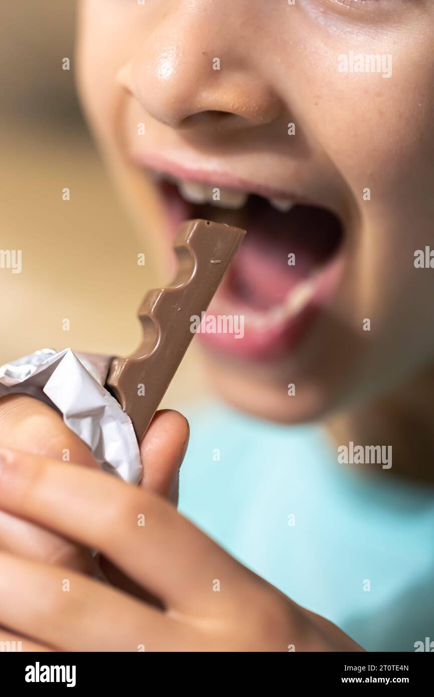 Detailed shot of a girl bites a chocolate bar. Stock Photo