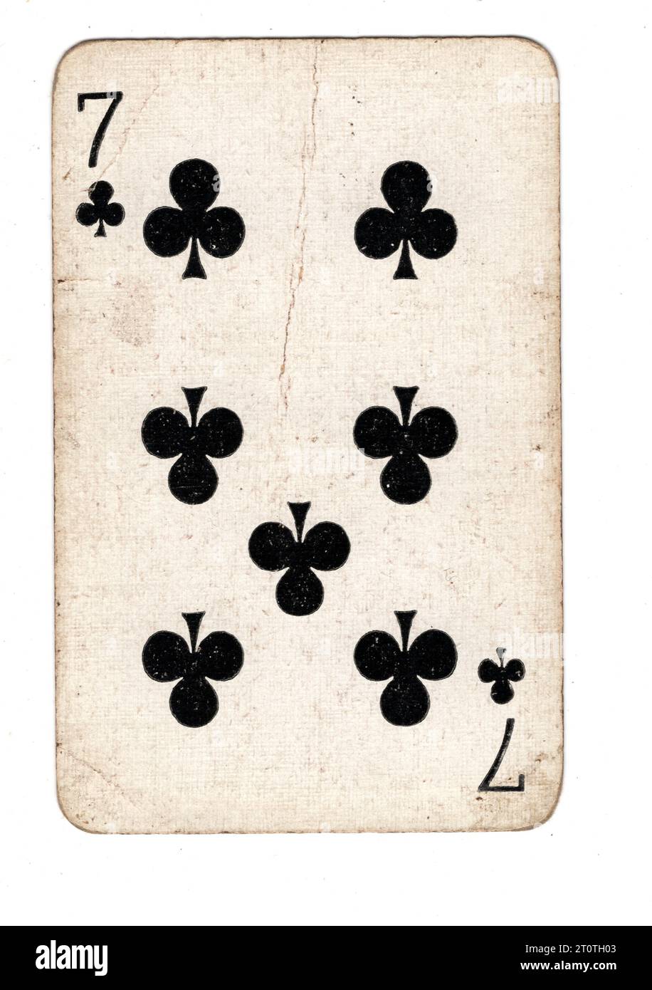 A vintage seven of clubs playing card isolated on a white background. Stock Photo