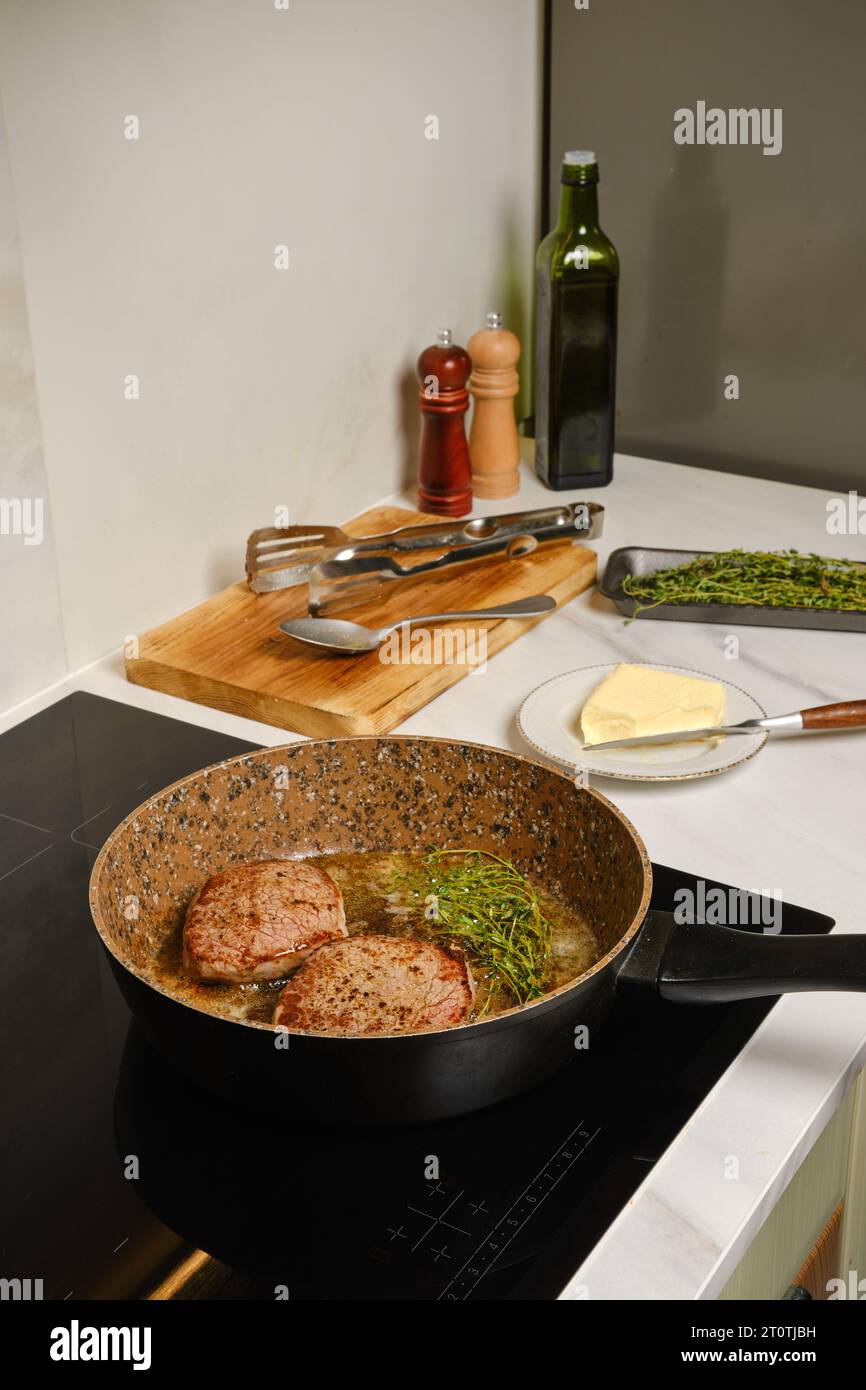 Making juicy beef steak at home on a stove Stock Photo