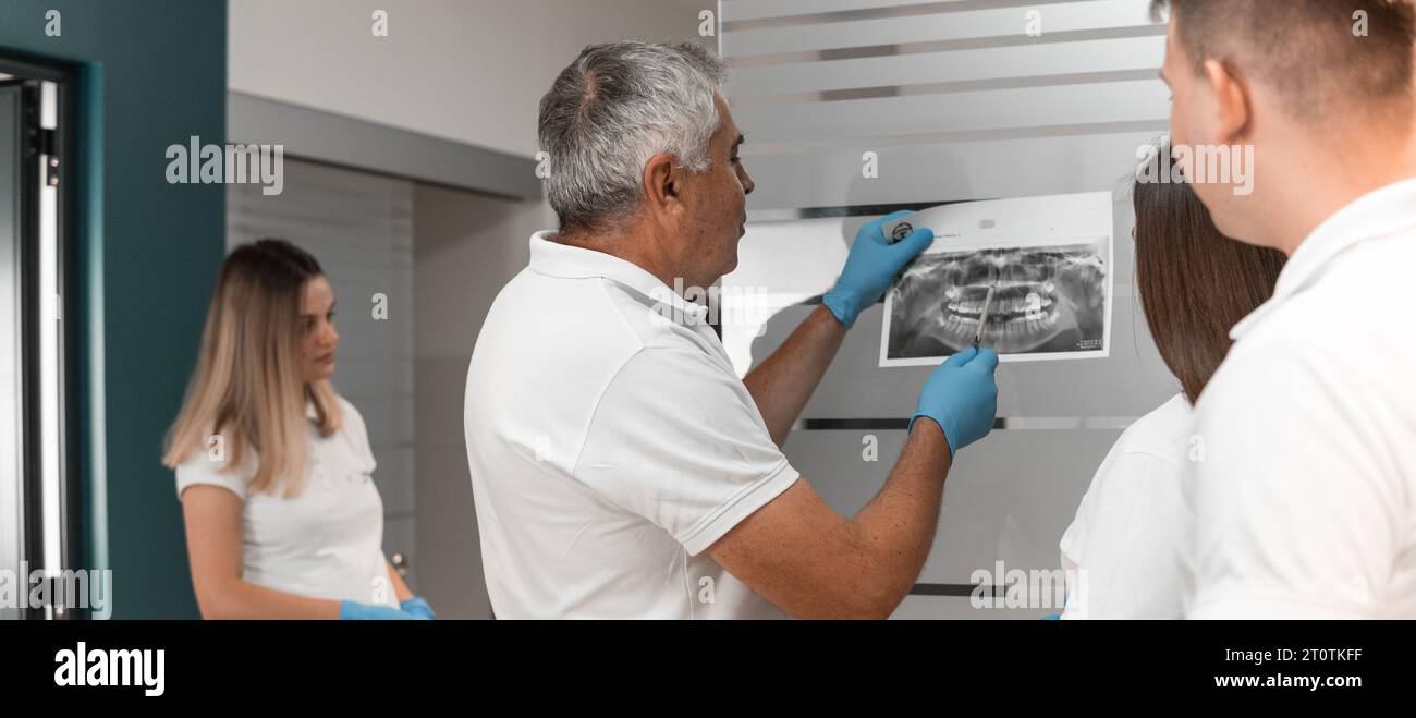 A team of dentists study Xray scans, MRI scans of oral teeth, discuss