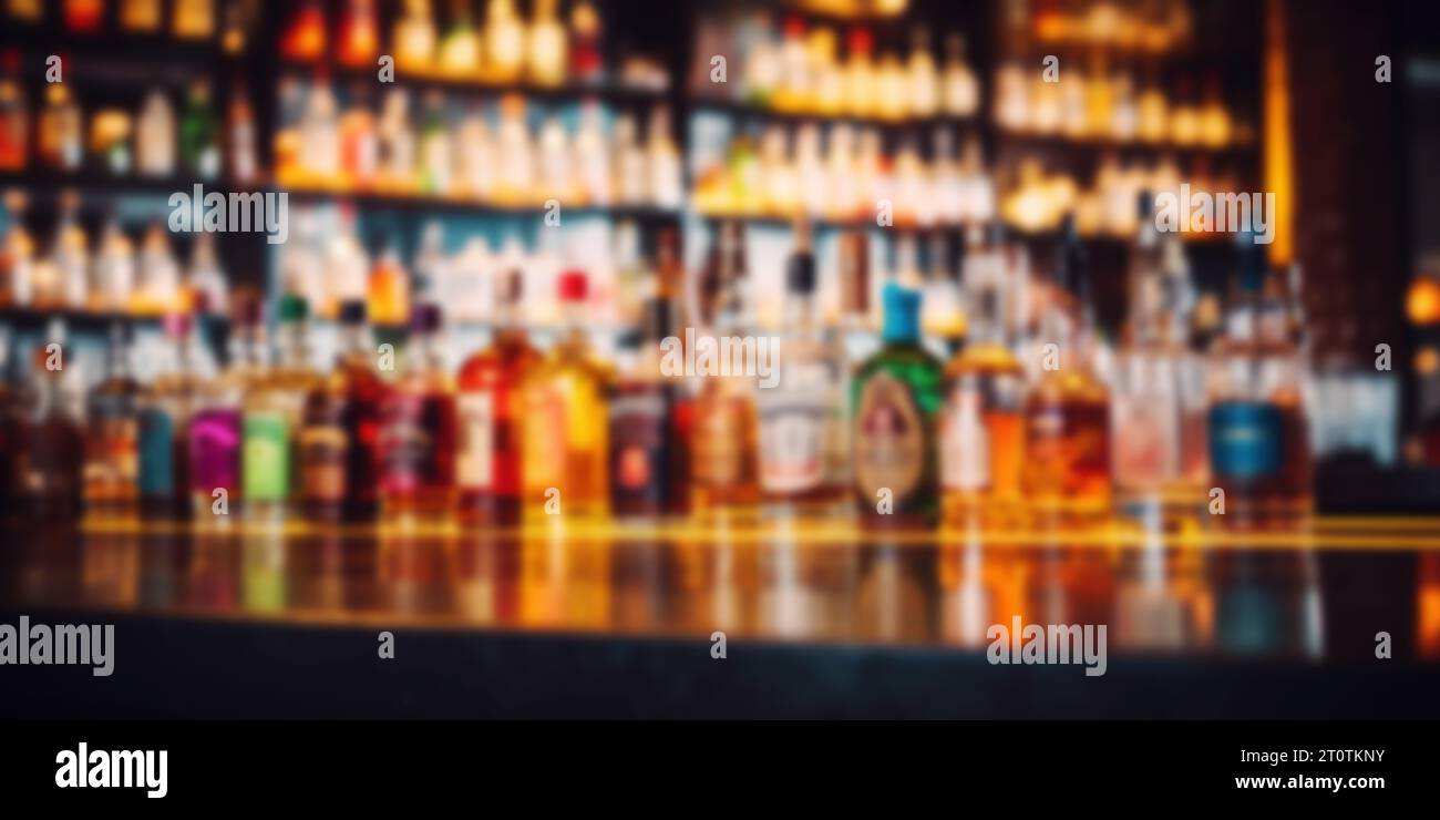 blurred alcohol bottles on bar counter and in shelves in background Stock Photo