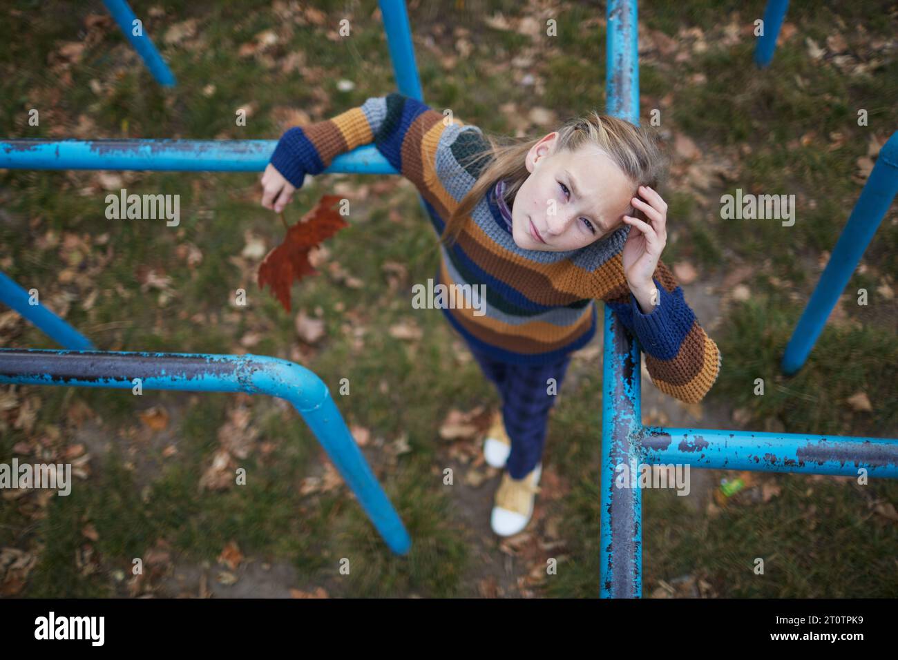 girl standing on monkey bars looking at camera Stock Photo