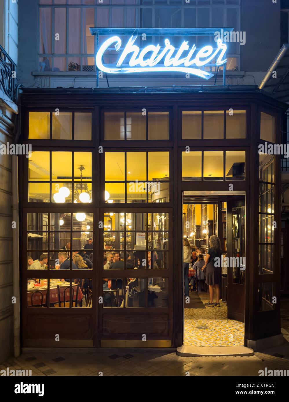 People inside the main entrance at the historic Art Nouveau style Bouillon Chartier restaurant