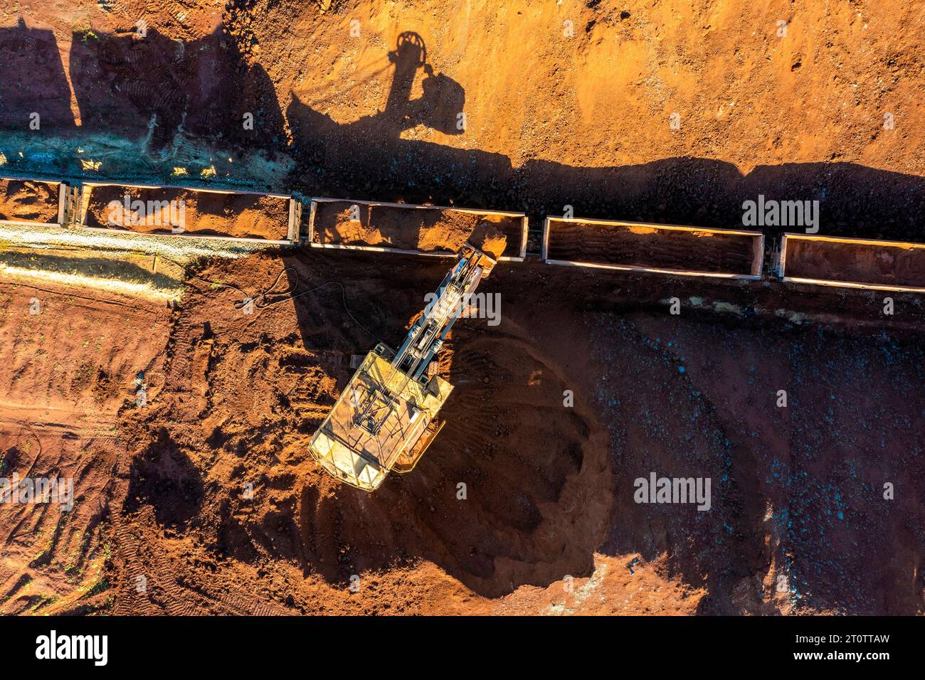 An excavator moving clay to  train wagons. Stock Photo