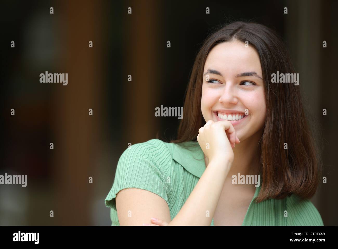 Happy woman thinking looking at side outdoors in the street Stock Photo