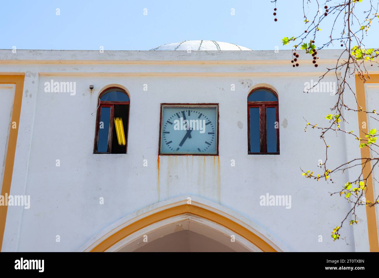 Gate wall of Rhodes city New Market (Nea Agora) with a clock showing the time of day Stock Photo